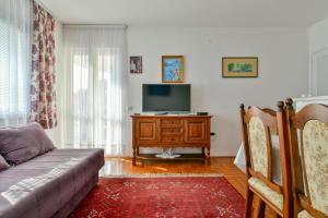 a living room with a couch and a flat screen tv at Apartment Ruzica in Sveti Stefan