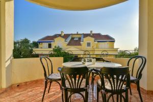 a table and chairs on a balcony with a house at Apartment Ruzica in Sveti Stefan