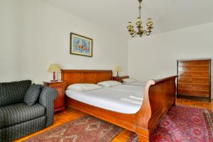 a bedroom with a bed and a couch and a chair at Apartment Ruzica in Sveti Stefan