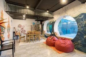 a room with a table and chairs and a large window at Hanuman VIP Hostel - SHA Plus in Bang Tao Beach