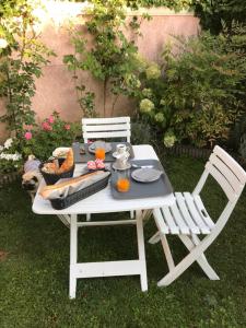 a white picnic table with two chairs and drinks on it at Rose Garden Mezzanine in Giverny +19 photos