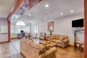 uma sala de estar com sofás e uma televisão de ecrã plano em Trident Inn & Suites, Baton Rouge em Baton Rouge