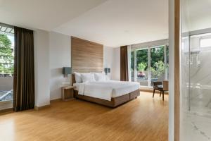 a bedroom with a bed and a large window at Adelphi Grande Sukhumvit in Bangkok