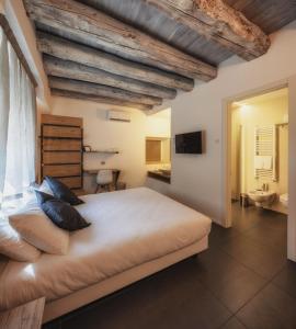 a bedroom with a large bed and a bathroom at Le Palme Rooms & Breakfast in Trento