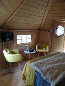 a bedroom with a bed and two chairs and a tv at Camping Loisirs Des Groux in Mousseaux-sur-Seine