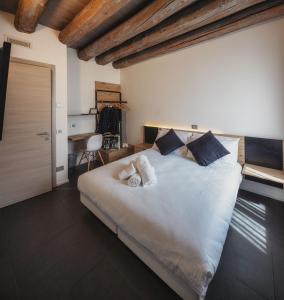een slaapkamer met een groot wit bed met kussens bij Le Palme Rooms & Breakfast in Trento