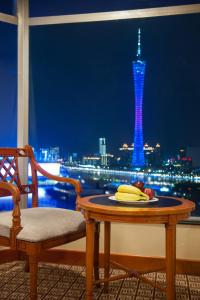 a table with a plate of fruit and a view of a tower at Ramada by Wyndham Pearl Guangzhou-Canton Fair Free Shuttle Bus in Guangzhou