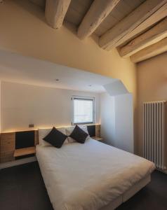 een slaapkamer met een groot wit bed met 2 kussens bij Le Palme Rooms & Breakfast in Trento