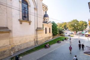 a group of people walking on a street next to a building at Modern apartment in Lviv historic centre in Lviv