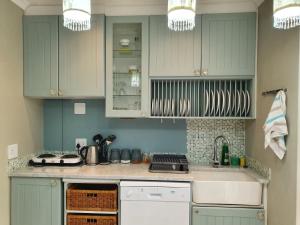 a kitchen with blue cabinets and a counter top at Kingfisher by the river - self catering in Velddrif
