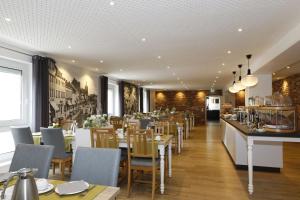 ein Restaurant mit Tischen und Stühlen und einer Bar in der Unterkunft Hotel Märkischer Hof in Luckenwalde
