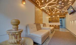 a living room with a couch and a tv at Hotel Amisha International in Surat