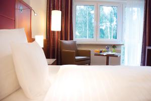 Ein Bett oder Betten in einem Zimmer der Unterkunft Morada Hotel Heidesee Gifhorn