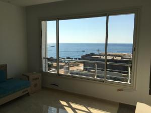a room with a large window with a view of the ocean at Arabesque Style - 2 appartements in Kelibia