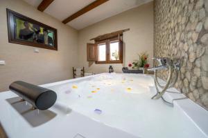 a large bathroom with a bath tub with a sink at Reul Alto Cortijos Rurales in Laroya