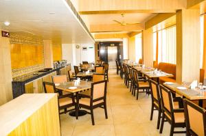 a restaurant with a row of tables and chairs at Hotel River Retreat in Kangra
