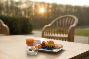 a plate of muffins and orange juice on a table at Golf Hotel de Mont Griffon in Luzarches +12 photos