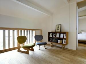 a room with two chairs and a bed and a book shelf at Kyo no Ondokoro NISHIJIN VILLA #5 in Kyoto