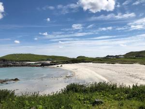 a beach with sand and the ocean on a sunny day at 10 Redcliffe in Stornoway