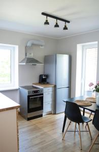 a kitchen with a table and a stainless steel refrigerator at Modern apartment in the heart of Kärdla in Kärdla