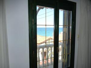 una puerta abierta con vistas al océano en Pension Eleni Studios, en Kokkari