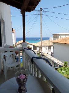 balcón con mesa y vistas al océano en Pension Eleni Studios, en Kokkari