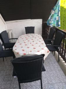 stół i krzesła z tkaniną stołową w obiekcie Simon Apartmanház Zamárdi w Zamárdi