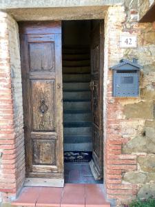 ルチニャーノにあるAppartamento Il Melogranoの木製のドアと階段のある建物の入口