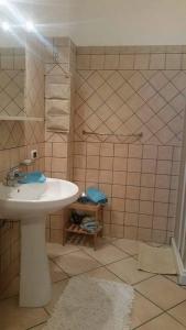 baño con lavabo blanco y pared de azulejos en B&B Antonella, en Perito
