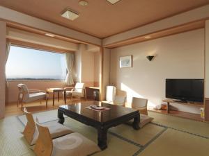 a living room with a coffee table and a television at Hokuten no Oka Abashiriko Tsuruga Resort in Abashiri