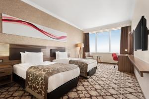A bed or beds in a room at Ramada by Wyndham Diyarbakir