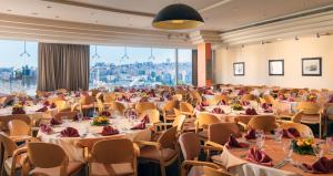 une grande salle de banquet avec des tables et des chaises dans l'établissement Ambassador Hotel, à Jérusalem