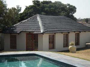 a house with a tile roof and a swimming pool at Lanseria Country Estate in Lanseria