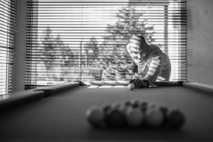 a man is playing pool in a pool table at Golf Hotel de Mont Griffon in Luzarches