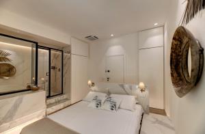 a bedroom with a white bed with two pillows at Le Palmette Suites in Cagliari