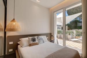 
a bedroom with a white bed and white walls at Le Palmette Suites B&B in Cagliari
