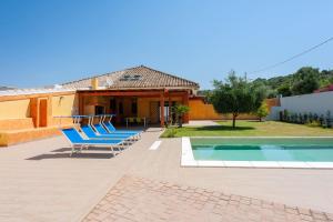 Villa con piscina y 2 sillones azules en Villa Chloe, en Santa Luria