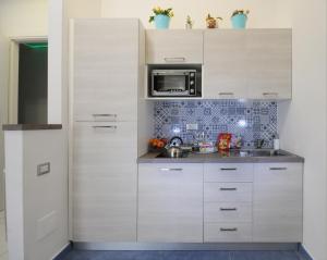 a kitchen with white cabinets and a microwave at Casa Sassolini in Naples