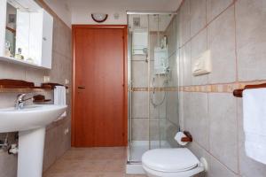 Un baño con ducha, inodoro y lavabo. en Villa Chloe, en Santa Luria 25 fotos más