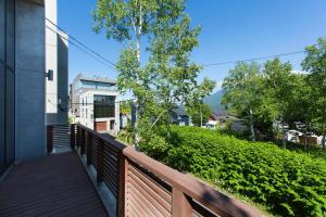 a balcony of a house with a wooden fence at Yuuki Toride Chalet in Niseko