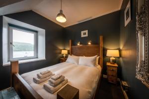 a bedroom with a bed with towels on it at Quayside Apartment in Portree