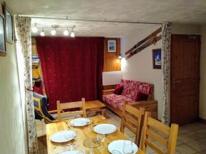 Chalets D'Or, Les Deux Alpes في مونت دي لانس: غرفة معيشة مع طاولة وكراسي وأريكة
