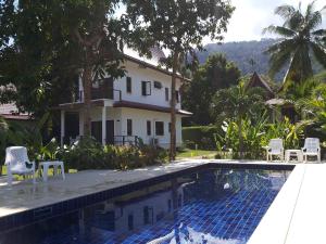 a house with a swimming pool in front of a house at Tulip Villa Oceanview in Ko Chang