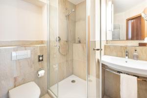a bathroom with a shower and a toilet and a sink at Bayerischer Hof in Freising