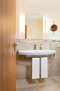 een badkamer met een wastafel en een spiegel bij Bayerischer Hof in Freising
