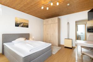 a bedroom with a large white bed and a wooden ceiling at Bayerischer Hof in Freising
