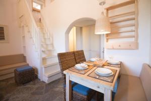 a dining room with a table and chairs and a staircase at Koutouloufari Village Holiday Club in Hersonissos