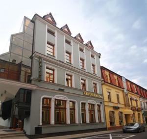 biały budynek na rogu ulicy w obiekcie Hotel Victoria we Włocławku