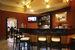 a bar in a restaurant with chairs and a television at Hotel Victoria in Włocławek