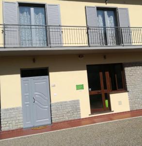 a building with a blue door and windows and a balcony at Affittacamere New Lifestyle in Alberoro